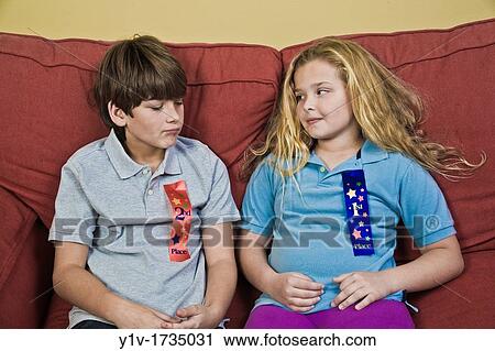 Stock Image - Brother and sister wearing 1st Place and 2nd Place ribbons. Fotosearch