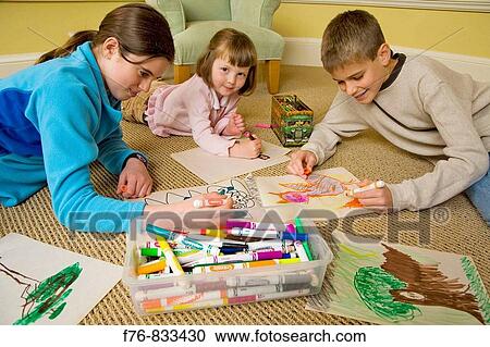 Brother and sisters sitting on rug and drawing in sketchbooks with colored markers and crayons View Large Photo Image Stock Image - Brother and sisters sitting on rug and drawing in sketchbooks with colored markers and crayons. Fotosearch