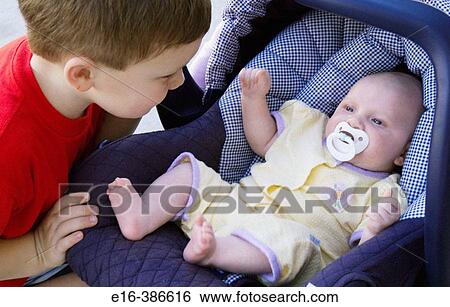 brother looking at baby sister in car seat View Large Photo Image Stock Photograph - brother looking at baby sister in car seat. Fotosearch