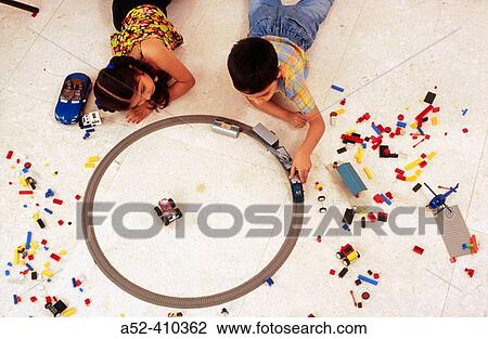 Stock Image - Brother sister playing with toy train.. Fotosearch