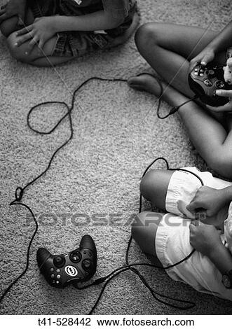 Brothers and sisters sit on the rug playing video games. Some anxiously await the turn at the remote. All watch the TV. View Large Photo Image Stock Image - Brothers and sisters sit on the rug playing video games. Some anxiously await the turn at the remote. All watch the TV.. Fotosearch