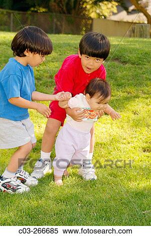 Stock Photography - Brothers and their year-old-sister amusing themselves. Laguna Beach. California. USA. Fotosearch