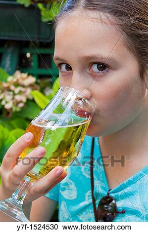 Stock Image - Brown eyed teenager drinking a glass of beer in a french caf?,Paris, France. Fotosearch
