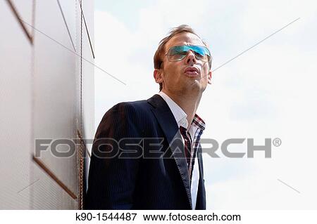 Brown haired young man with sunglasses, looking into the far distance, leaning relaxed at a wall, Hamburg, Germany, Europe View Large Photo Image Stock Photo - Brown haired young man with sunglasses, looking into the far distance, leaning relaxed at a wall, Hamburg, Germany, Europe. Fotosearch