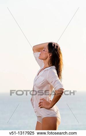 Brunette beautiful woman stretching by the sea View Large Photo Image Stock Photography - Brunette beautiful woman stretching by the sea. Fotosearch