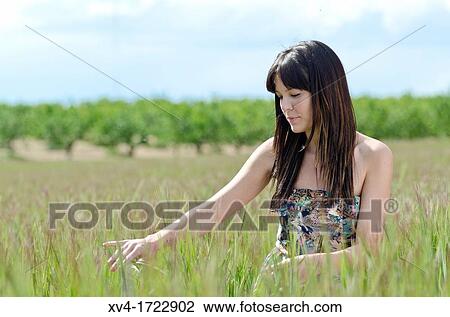 Stock Image - Brunette breathing fresh air in the ruralscape. Fotosearch
