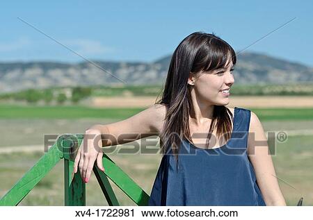 Stock Image - Brunette breathing fresh air in the ruralscape. Fotosearch