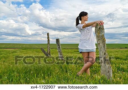 Stock Photo - Brunette breathing fresh air in the ruralscape. Fotosearch