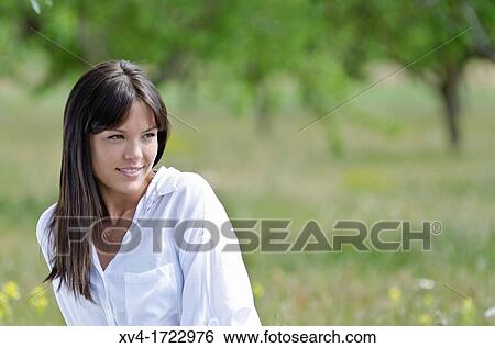 Stock Photograph - Brunette breathing fresh air in the ruralscape. Fotosearch