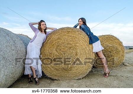 Brunette couple relaxing on bale and enjoy in the countryside looking at camera View Large Photo Image Stock Photo - Brunette couple relaxing on bale and enjoy in the countryside looking at camera. Fotosearch