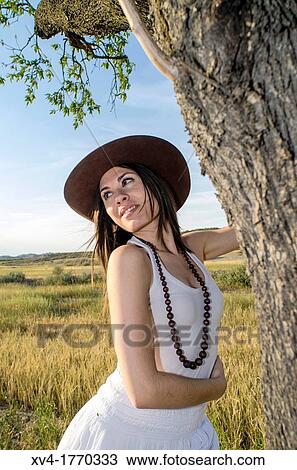 Brunette on the tree enjoy in the countryside View Large Photo Image Stock Image - Brunette on the tree enjoy in the countryside. Fotosearch