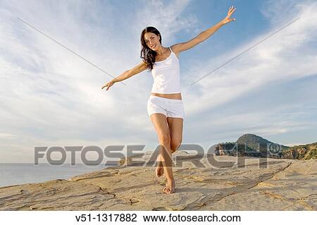 Brunette palyful woman in a cliff in Ibiza, Balearic Islands View Large Photo Image Stock Image - Brunette palyful woman in a cliff in Ibiza, Balearic Islands. Fotosearch