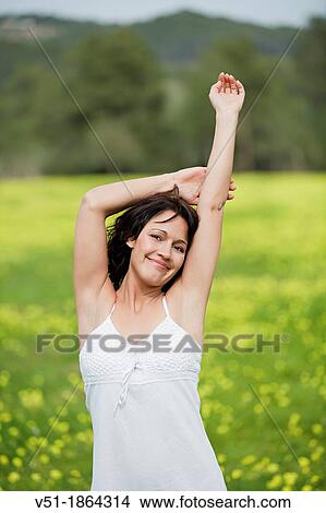 Brunette pretty woman breathing fresh air in countryside smiling at camera View Large Photo Image Picture - Brunette pretty woman breathing fresh air in countryside smiling at camera. Fotosearch
