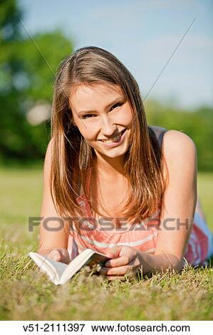 Brunette pretty woman in park reading a book and smiling at camera View Large Photo Image Stock Photo - Brunette pretty woman in park reading a book and smiling at camera. Fotosearch