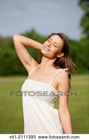 Brunette pretty woman in park smiling feeling good View Large Photo Image Stock Image - Brunette pretty woman in park smiling feeling good. Fotosearch