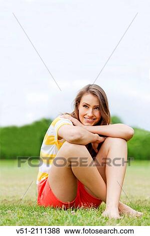 Stock Photo - Brunette pretty woman in park smiling. Fotosearch