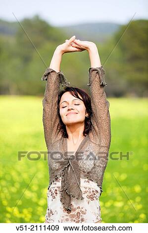 Brunette pretty woman stretching in park smiling and feeling good View Large Photo Image Stock Photo - Brunette pretty woman stretching in park smiling and feeling good. Fotosearch