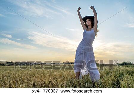 Brunette relaxing in the countryside with arms raised View Large Photo Image Stock Photo - Brunette relaxing in the countryside with arms raised. Fotosearch