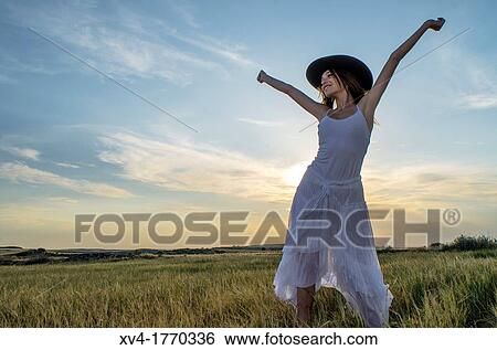 Brunette relaxing in the countryside with arms raised View Large Photo Image Stock Photograph - Brunette relaxing in the countryside with arms raised. Fotosearch