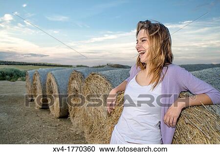 Brunette relaxing on bale in the countryside View Large Photo Image Stock Image - Brunette relaxing on bale in the countryside. Fotosearch