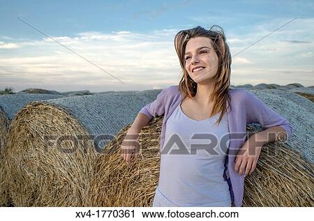Brunette relaxing on bale in the countryside View Large Photo Image Stock Image - Brunette relaxing on bale in the countryside. Fotosearch