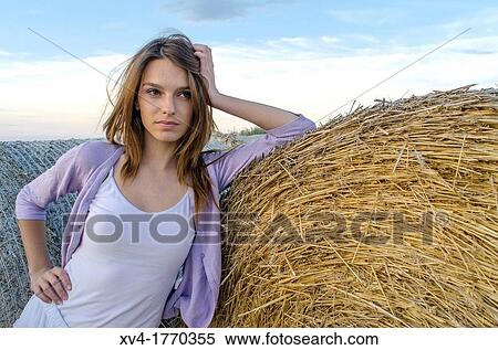 Brunette relaxing on bale in the countryside View Large Photo Image Stock Photography - Brunette relaxing on bale in the countryside. Fotosearch