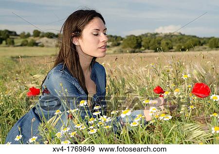 Brunette relaxing with poppy and enjoy in the countryside View Large Photo Image Stock Photo - Brunette relaxing with poppy and enjoy in the countryside. Fotosearch