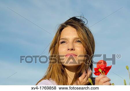 Brunette relaxing with poppy and enjoy in the countryside View Large Photo Image Stock Photo - Brunette relaxing with poppy and enjoy in the countryside. Fotosearch