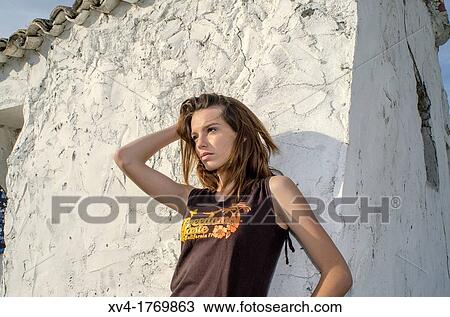 Brunette standing on wall of white facade house in the countryside View Large Photo Image Stock Image - Brunette standing on wall of white facade house in the countryside. Fotosearch