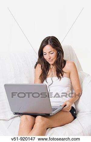 Stock Photo - Brunette woman at home with laptop. Fotosearch