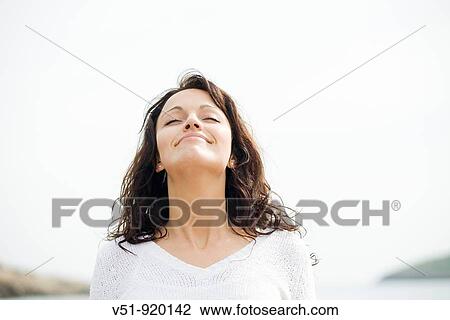 Brunette woman by the sea breathing fresh air View Large Photo Image Stock Image - Brunette woman by the sea breathing fresh air. Fotosearch