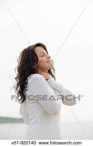 Brunette woman by the sea brething fresh air View Large Photo Image Stock Image - Brunette woman by the sea brething fresh air. Fotosearch