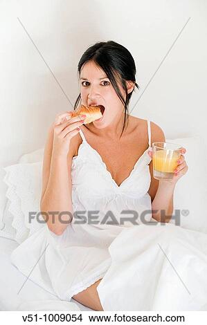 Brunette woman enjoying breakfast in bed View Large Photo Image Picture - Brunette woman enjoying breakfast in bed. Fotosearch