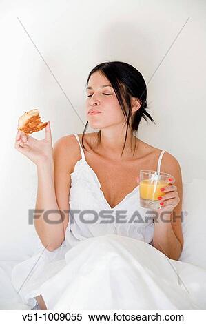 Brunette woman enjoying breakfast in bed View Large Photo Image Stock Photography - Brunette woman enjoying breakfast in bed. Fotosearch