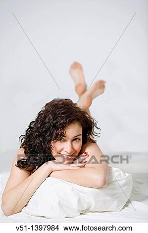 Brunette woman lying down in bed View Large Photo Image Picture - Brunette woman lying down in bed. Fotosearch