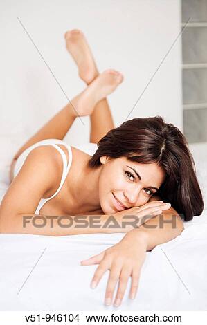 Brunette woman lying down in bed View Large Photo Image Picture - Brunette woman lying down in bed. Fotosearch