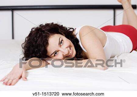 Brunette woman lying down in bed View Large Photo Image Stock Image - Brunette woman lying down in bed. Fotosearch