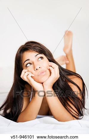 Brunette woman lying down in bed daydreaming View Large Photo Image Stock Image - Brunette woman lying down in bed daydreaming. Fotosearch