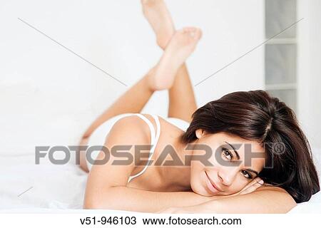 Brunette woman lying down in bed View Large Photo Image Stock Image - Brunette woman lying down in bed. Fotosearch