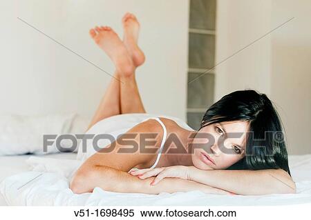 Brunette woman lying down in bed View Large Photo Image Stock Photography - Brunette woman lying down in bed. Fotosearch