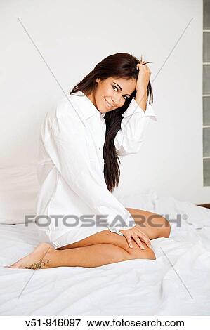 Brunette woman posing on bed View Large Photo Image Stock Photo - Brunette woman posing on bed. Fotosearch