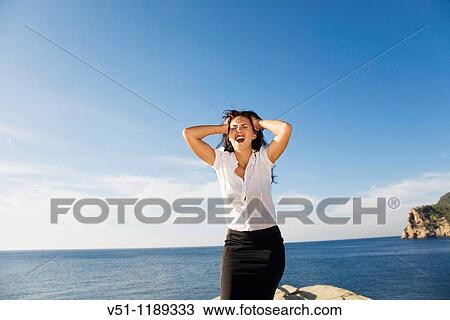 Brunette woman screaming in a rock by the sea View Large Photo Image Stock Image - Brunette woman screaming in a rock by the sea. Fotosearch