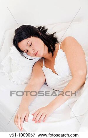 Brunette woman sleeping in bed View Large Photo Image Stock Photo - Brunette woman sleeping in bed. Fotosearch