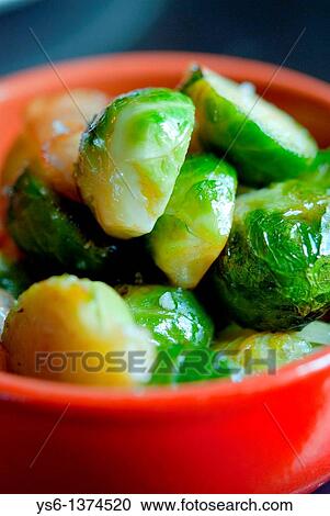 Stock Image - Brussel sprouts in an orange bowl. Fotosearch