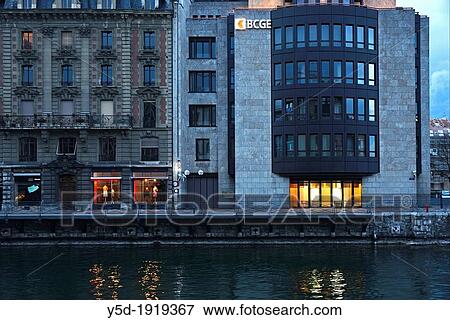buildings of Geneva at dusk, located on a small island on the Rhone river - I? Ile, BCGE building - Banque Cantonale de Gen? ve and old residential building, reflections in Rhone river, center of the city next to Bel Air, Geneva, Switzerland, Europe View Large Photo Image Stock Photo - buildings of Geneva at dusk, located on a small island on the Rhone river - I? Ile, BCGE building - Banque Cantonale de Gen? ve and old residential building, reflections in Rhone river, center of the city next to Bel Air, Geneva, Switzerland, Europe. Fotosearch