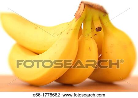Bunch of bananas, laying on wooden cutting board on white background Shot with LensBaby for selective focus View Large Photo Image Stock Image - Bunch of bananas, laying on wooden cutting board on white background Shot with LensBaby for selective focus. Fotosearch