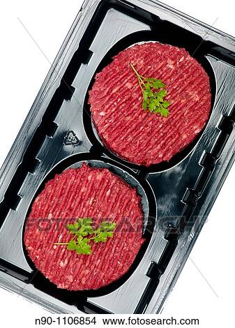 Burger patties in a supermarket packaging tray isolated on a white background View Large Photo Image Picture - Burger patties in a supermarket packaging tray isolated on a white background. Fotosearch