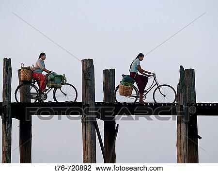 Burmese girls riding bikes on the U Bein teak bridge in Myanmar View Large Photo Image Stock Image - Burmese girls riding bikes on the U Bein teak bridge in Myanmar. Fotosearch
