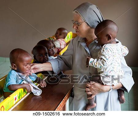 Stock Photograph - Burundi, nun with orphans. Fotosearch