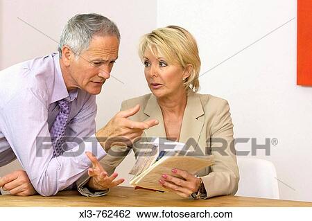 Stock Image - Business couple arguing over papers. Fotosearch